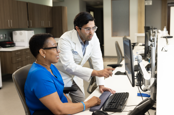 Nurse and Doctor sitting at a desk looking at test results on a computer